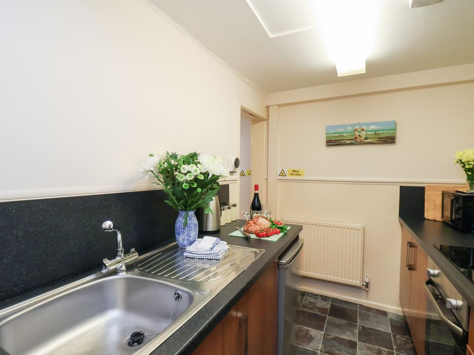 A kitchen with a sink and food items at Stowaway Cottage in Whitby