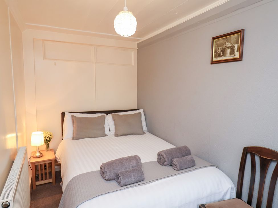 A bedroom with a bed and towels at Stowaway Cottage Whitby