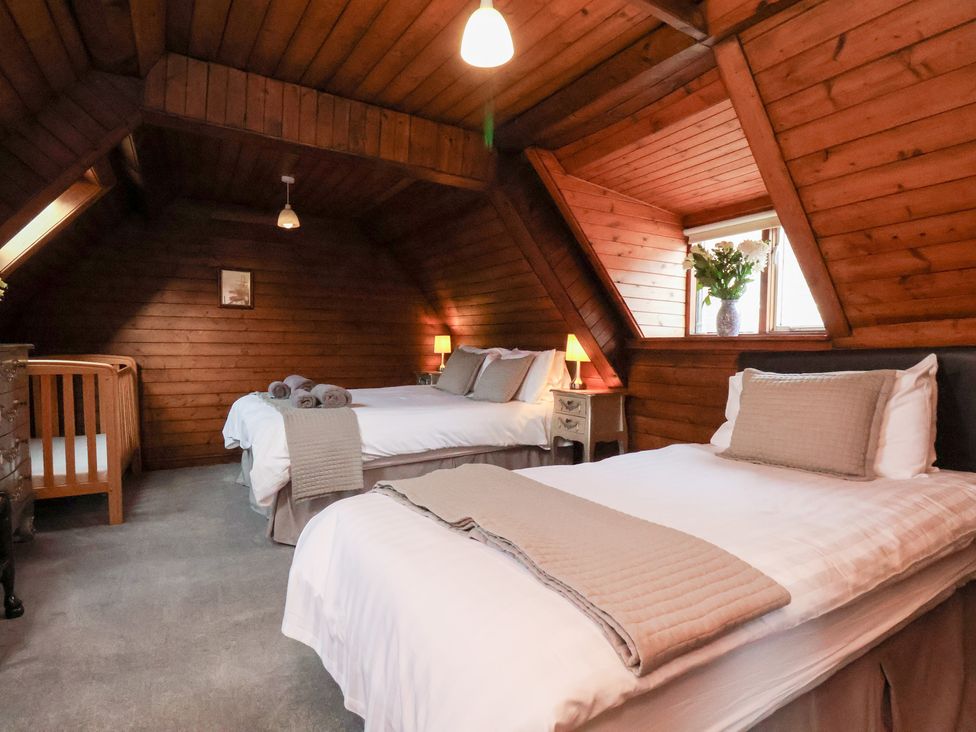 A bedroom with two beds and a crib at Stowaway Cottage in Whitby