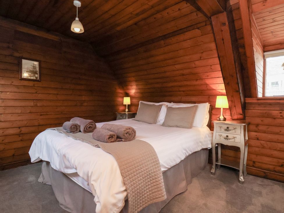 A bedroom with a bed and bedside lamps at Stowaway Cottage in Whitby