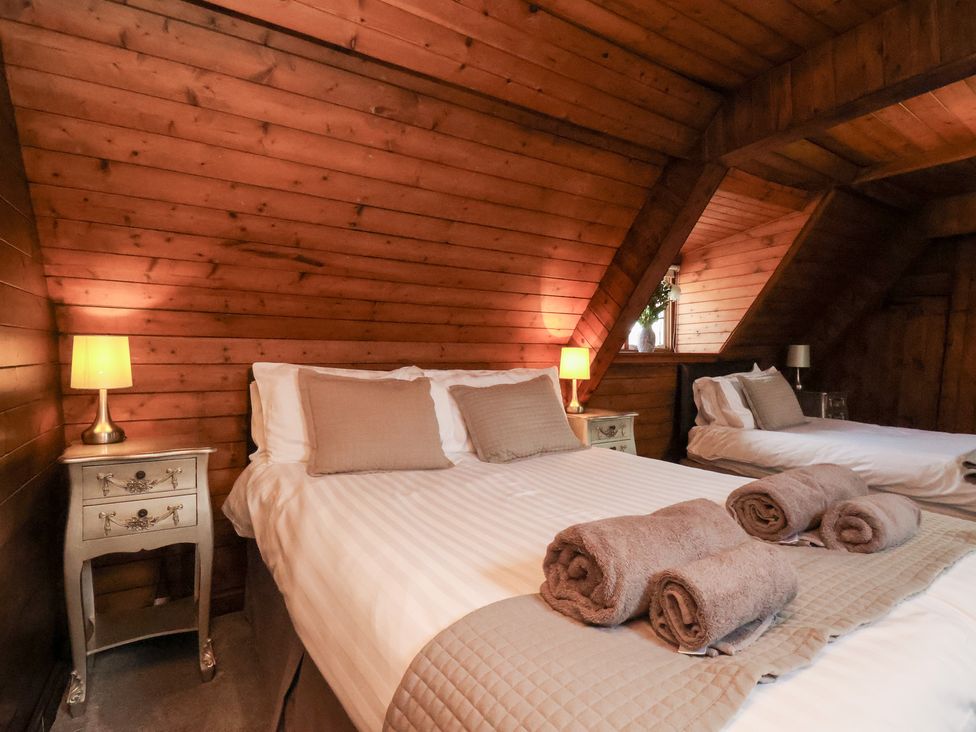 A bedroom with two beds and a nightstand at Stowaway Cottage in Whitby