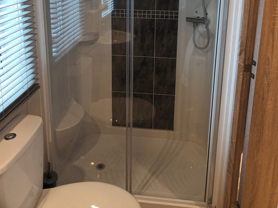 A bathroom with a toilet and shower at Fern Lodge in Stowmarket