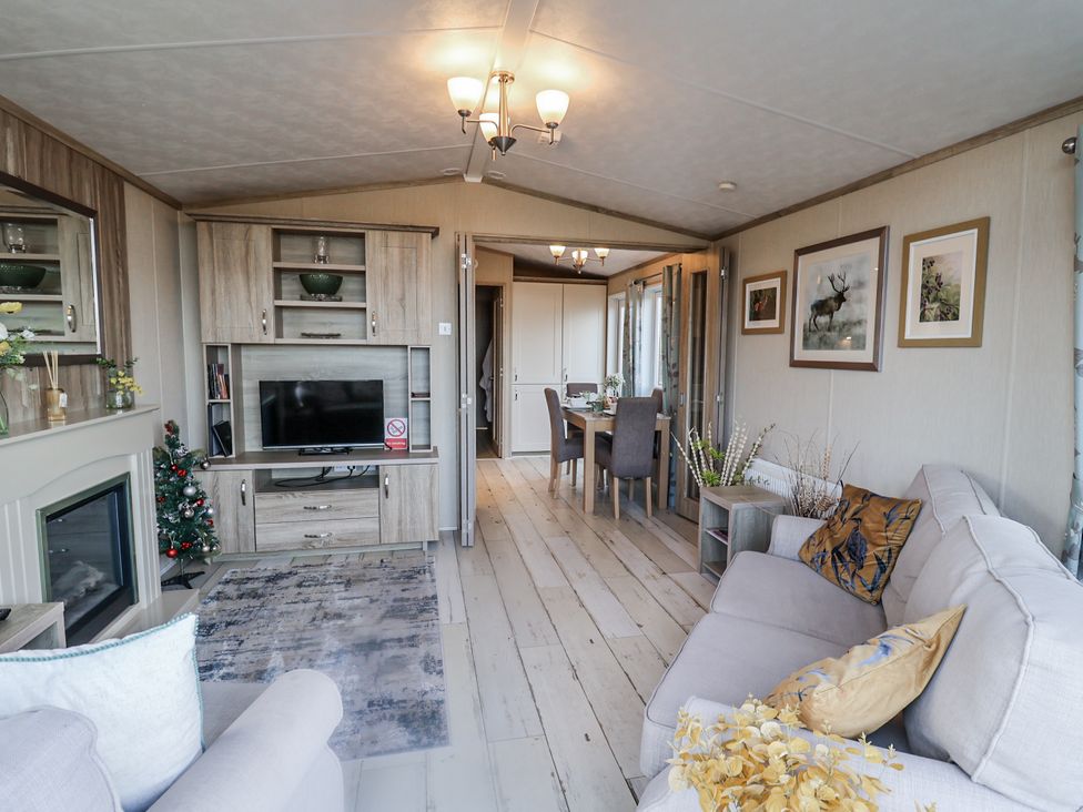 A living room with a sofa and television at Fern Lodge in Stonham Aspal