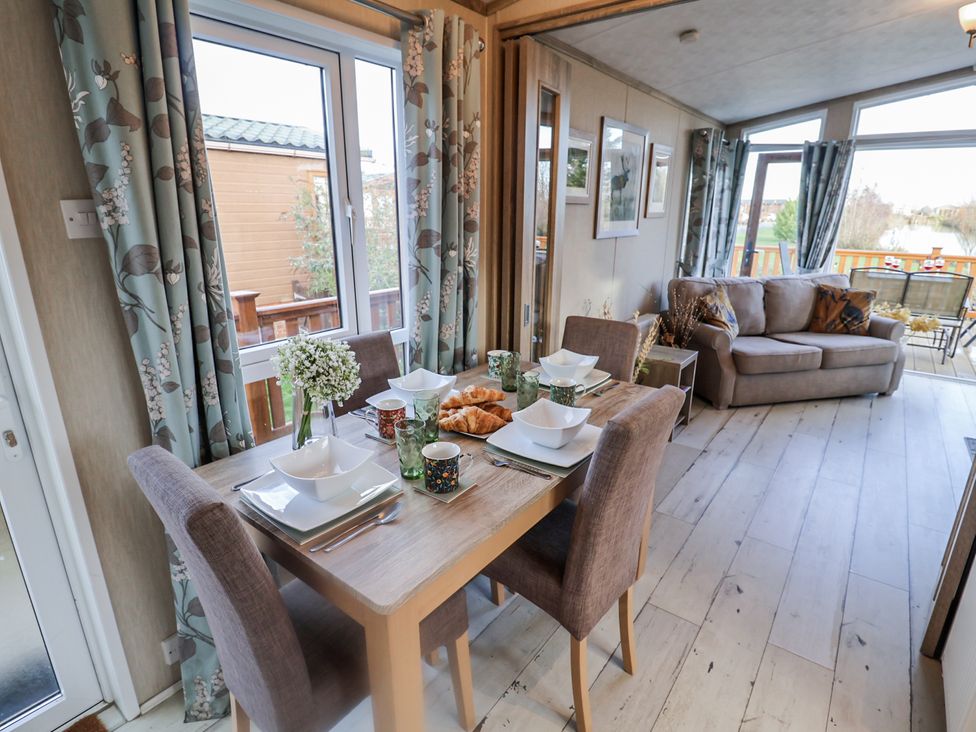 A dining room with a table set for a meal at Fern Lodge in Stonham Aspal
