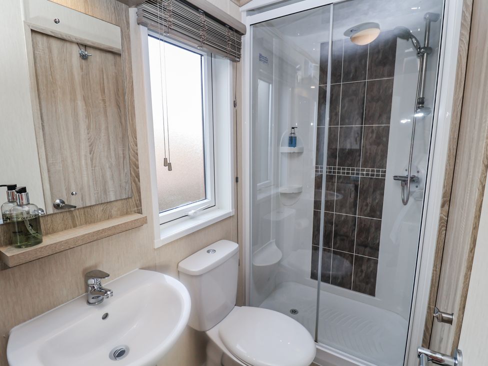 A bathroom with a shower, sink, and toilet at Fern Lodge in Stonham Aspal