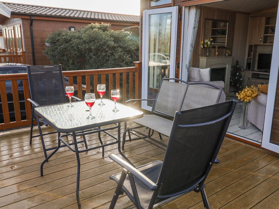 An outdoor seating area with a table and chairs at Fern Lodge, Stonham Aspal