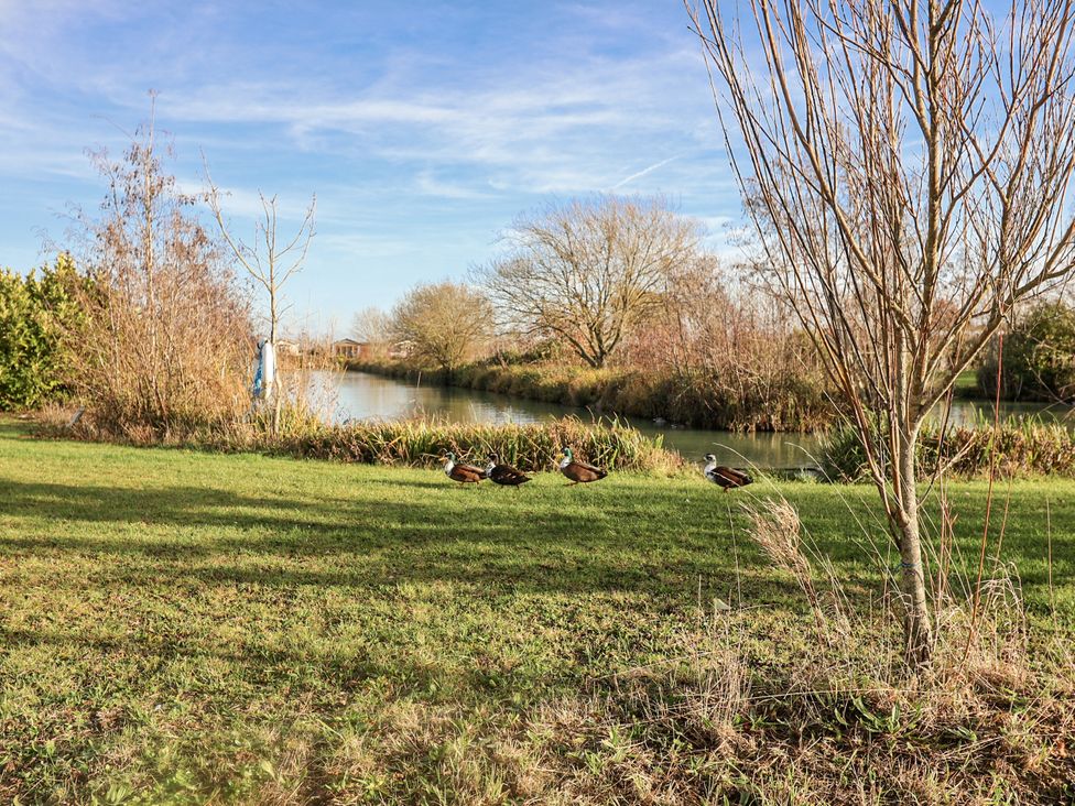 A garden with a river and ducks at Fern Lodge in Stonham Aspal