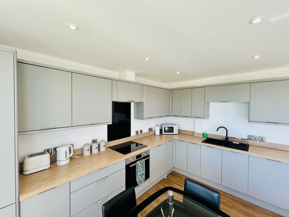 A kitchen with cabinets, countertop, sink, oven, and appliances at 2A Hamilton Road in Felixstowe