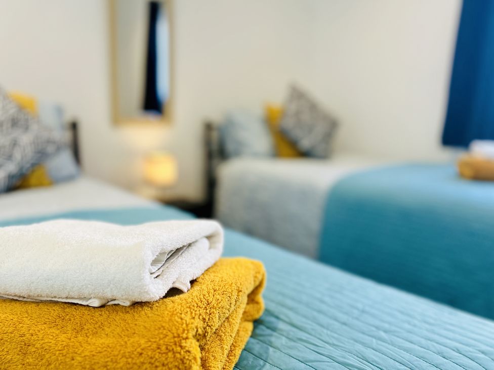 A bedroom with beds and towels at 2A Hamilton Road, Felixstowe