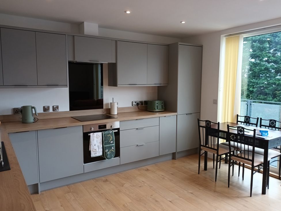 A kitchen with cabinets and a table at 2B Hamilton Road in Felixstowe