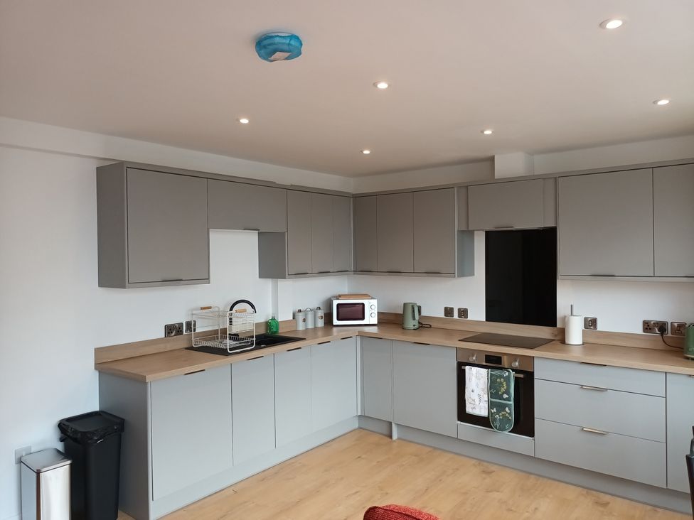 A kitchen with cabinets, microwave, kettle, and sink at 2B Hamilton Road in Felixstowe