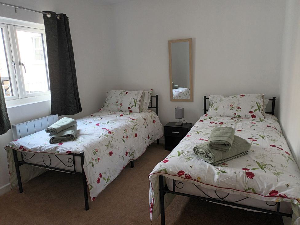 A bedroom with two beds and a mirror at 2B Hamilton Road in Felixstowe
