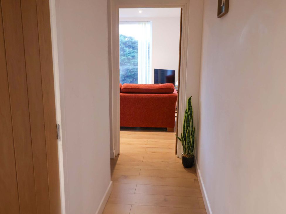 A hallway leading to a living room with a sofa and television at 2B Hamilton Road, Felixstowe, Suffolk