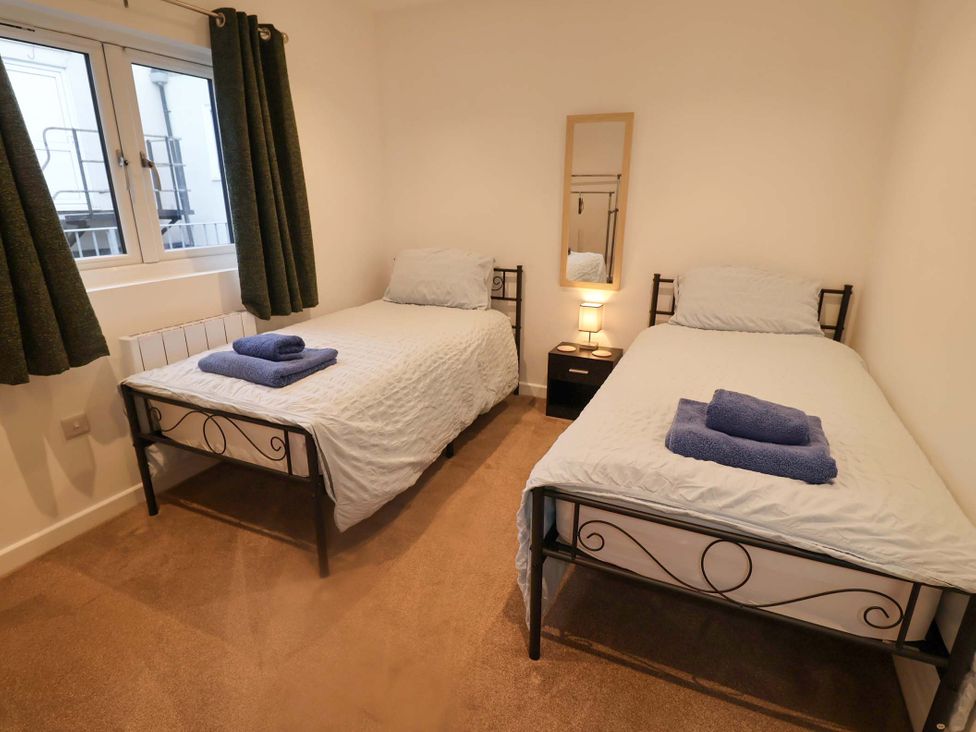 A bedroom with two single beds and a nightstand at 2B Hamilton Road, Felixstowe, Suffolk