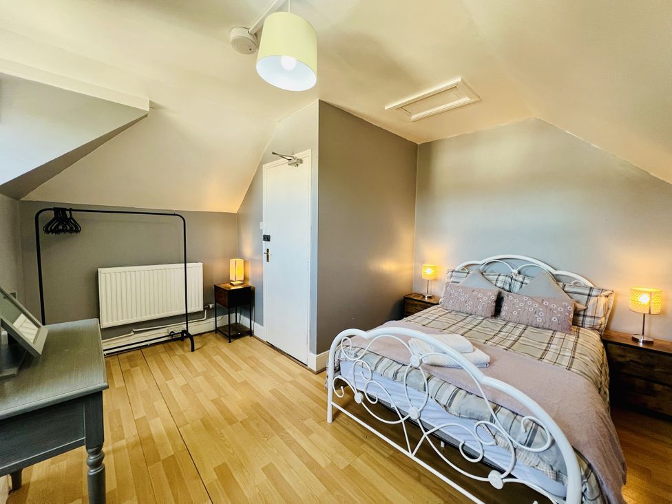 A bedroom with a bed and nightstands at 11 Langer Road in Felixstowe