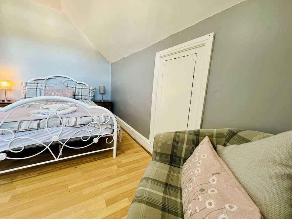 A bedroom with a bed and a sofa at 11 Langer Road in Felixstowe