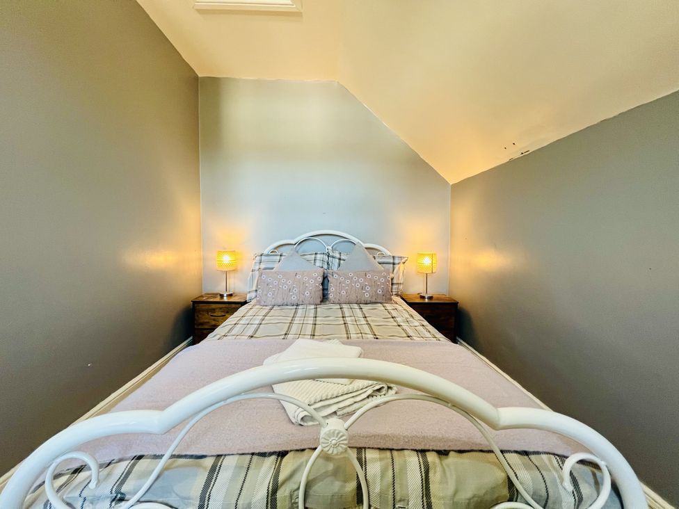 A bedroom with a bed and bedside table with lamp at 11 Langer Road Felixstowe