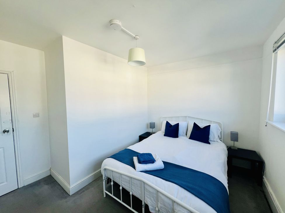 A bedroom with a bed and bedside tables at 11 Langer Road in Felixstowe