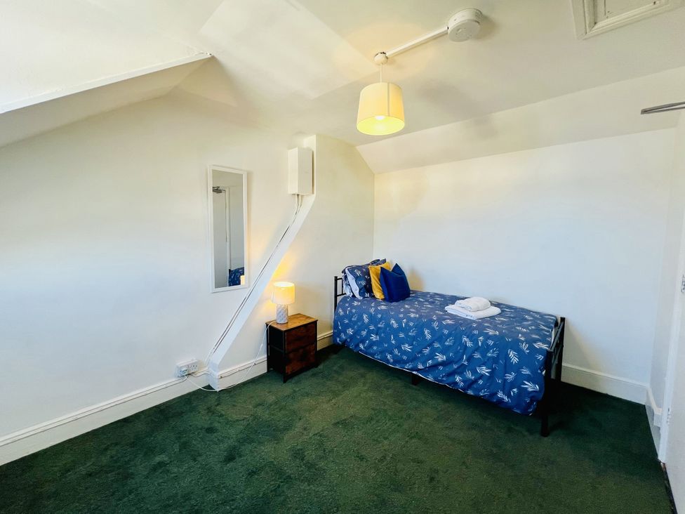 A bedroom with a bed and a nightstand at 11 Langer Road in Felixstowe