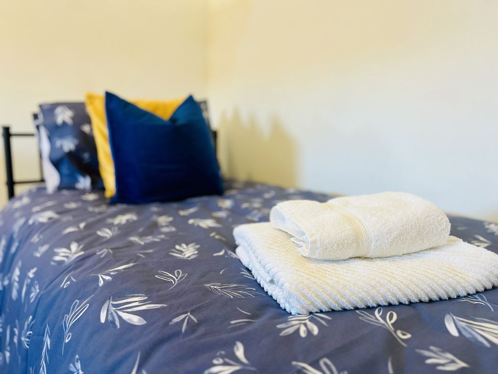 A bed with towels and pillows at 11 Langer Road, Felixstowe