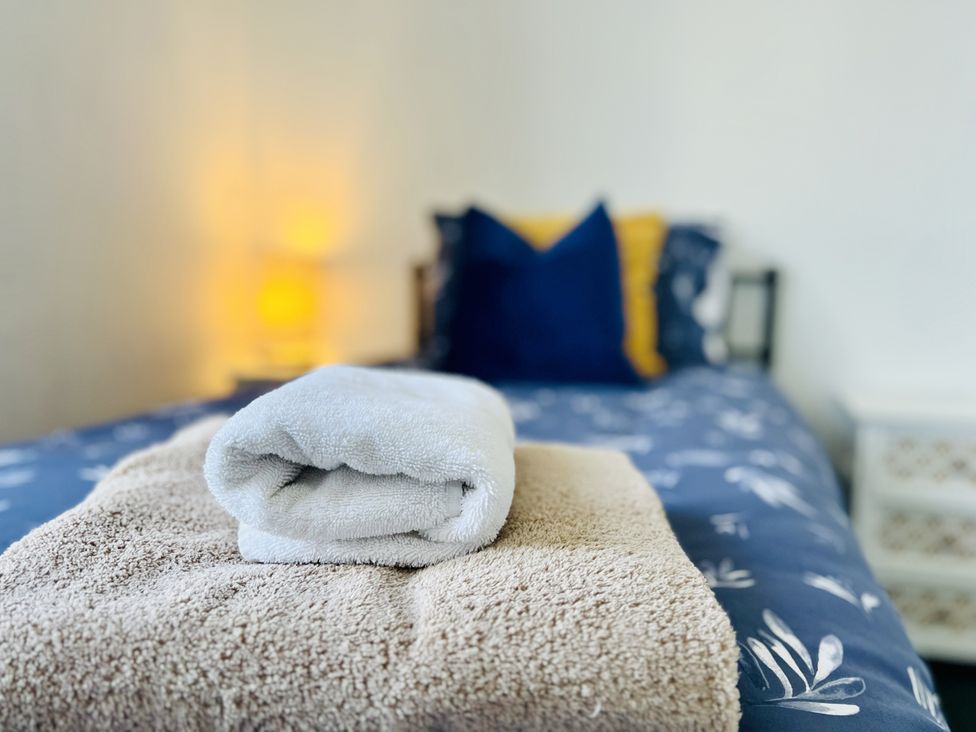 A bed with towels and pillows at 11 Langer Road, Felixstowe