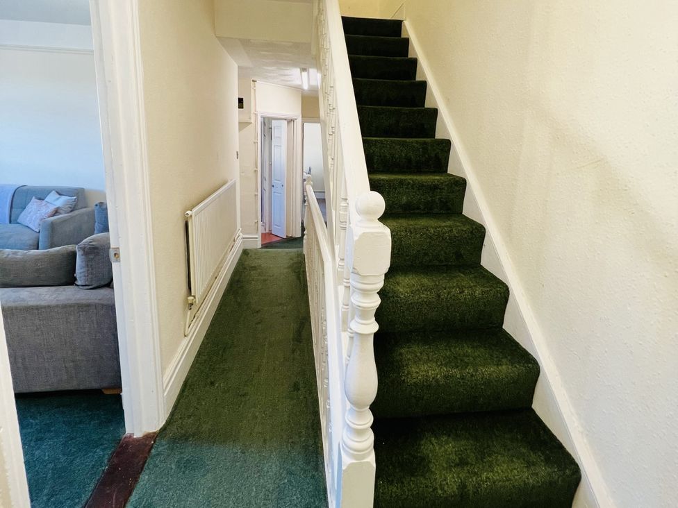 A staircase and hallway with carpet at 11 Langer Road in Felixstowe