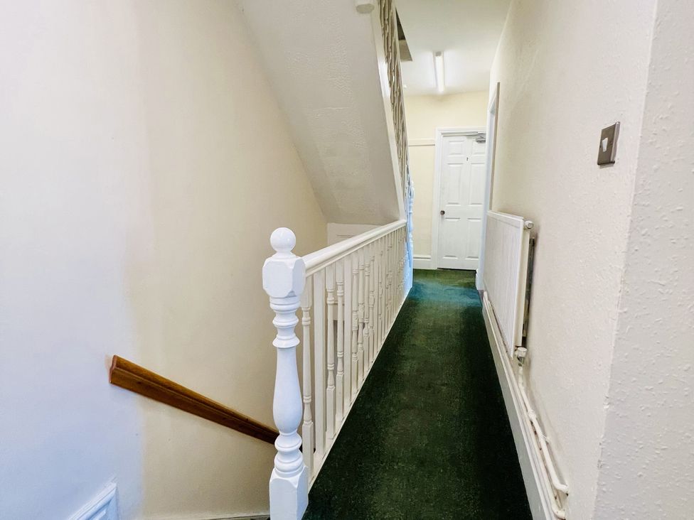 A hallway with a stair railing and door at 11 Langer Road Felixstowe