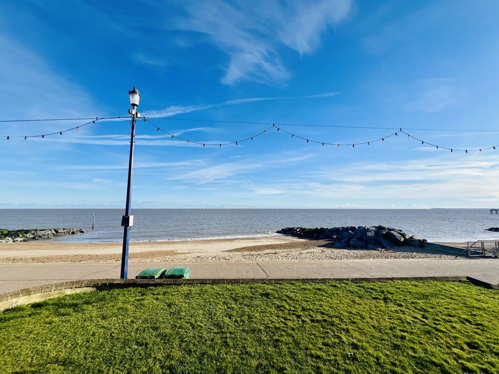A beach view with rocks and a lamp post at 11 Langer Road in Felixstowe