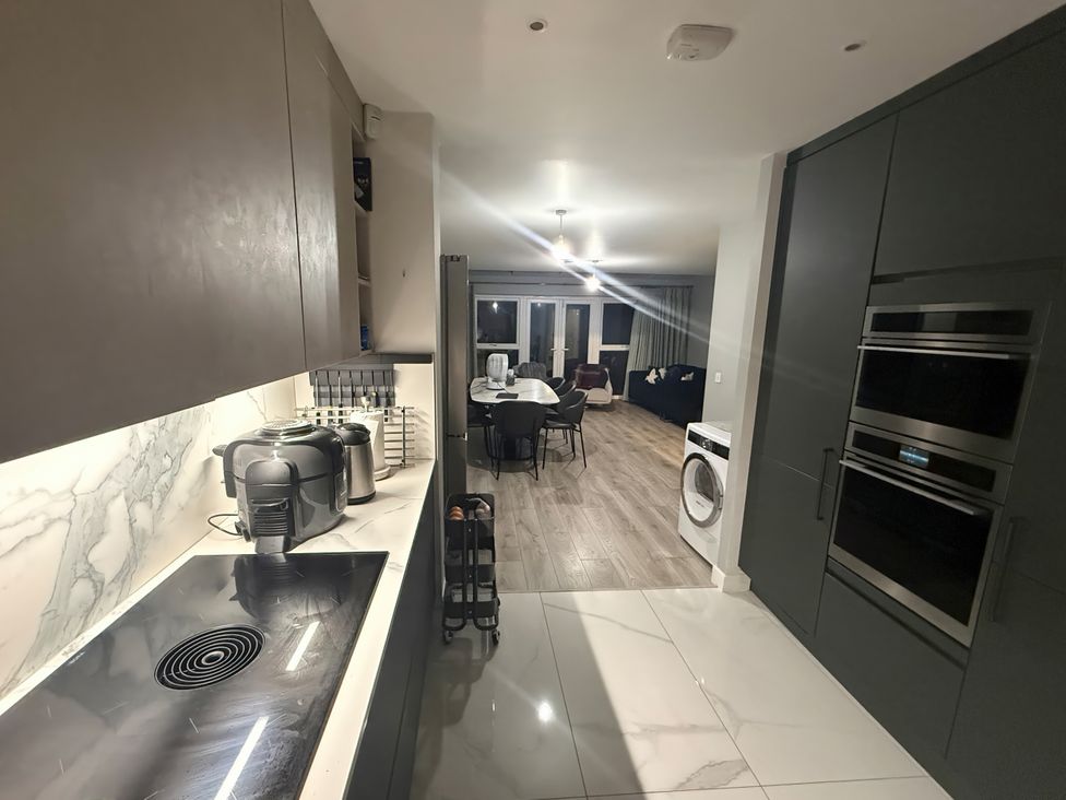 A kitchen with modern appliances and dining area at 14 Becket Close Woodford Green