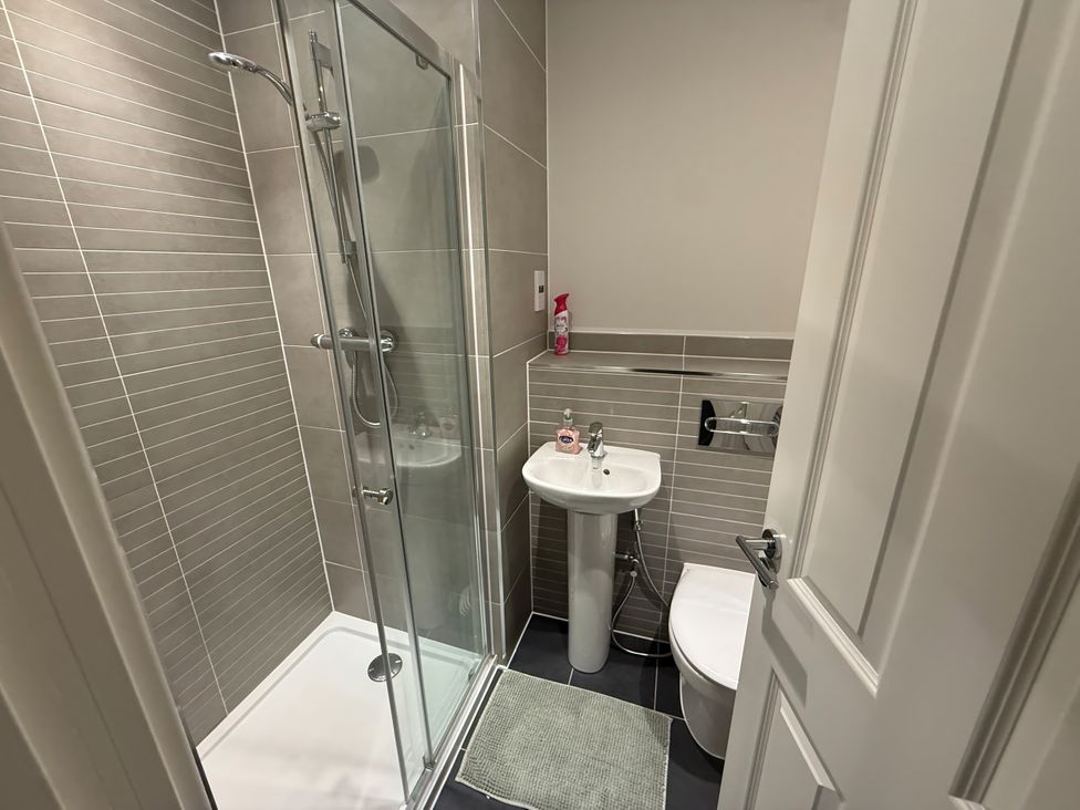 A bathroom with a shower and a sink at 14 Becket Close in Woodford Green