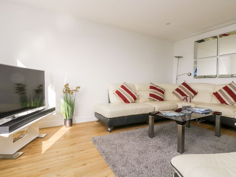 A living room with a sofa and television at Praa Waves in Penzance
