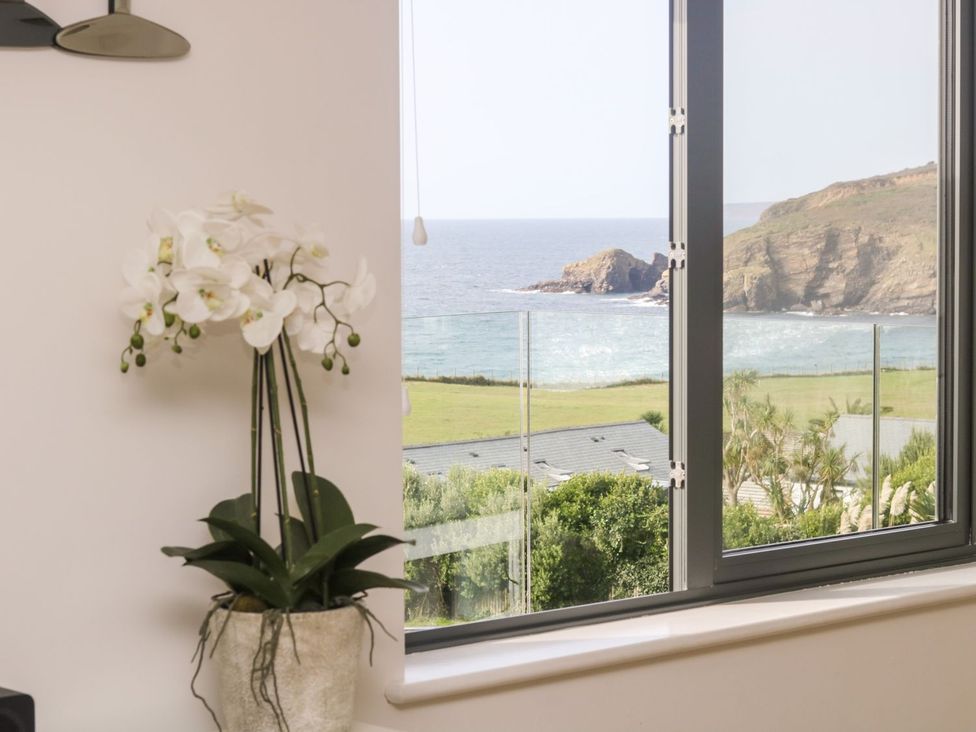 A window with a flower pot overlooking the sea at Praa Waves in Penzance