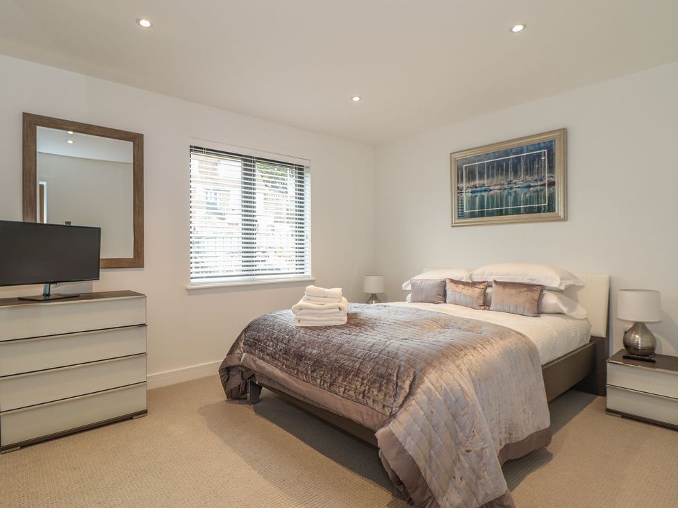 A bedroom with a bed, television, and dresser at Praa Waves in Penzance