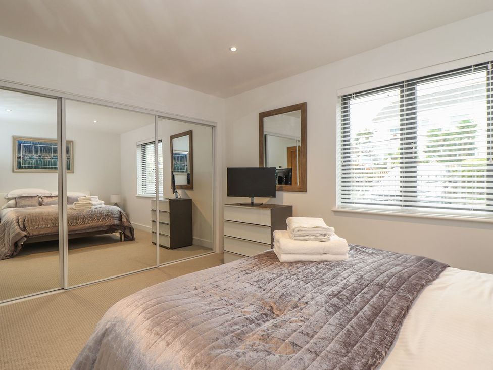 A bedroom with a bed and a television at Praa Waves in Penzance