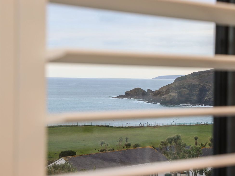 View of ocean and coastline through window blinds at Praa Waves in Penzance