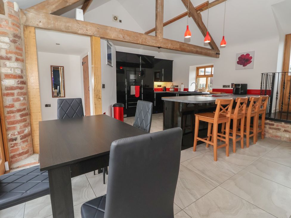 A kitchen with a dining area and bar stools at Pillar Barn Driffield