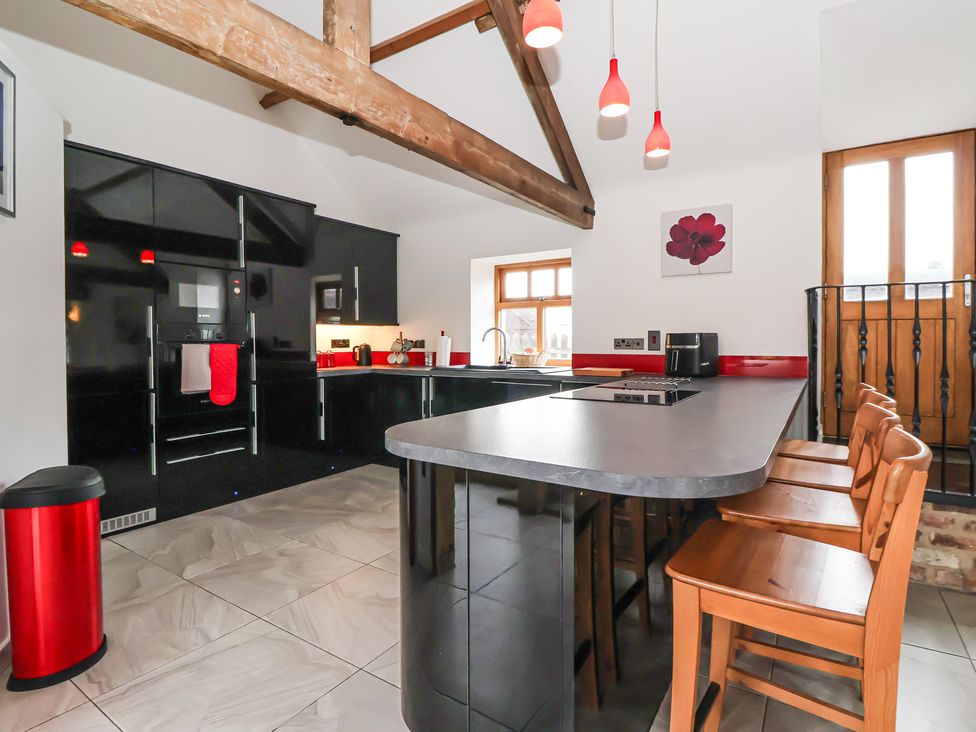A kitchen with a kitchen island and bar stools at Pillar Barn Driffield