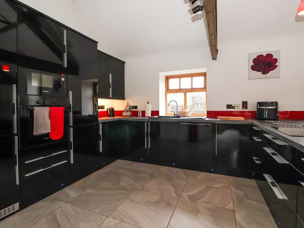 A kitchen with black cabinets and a window at Pillar Barn Driffield