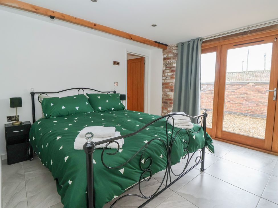 A bedroom with a bed and window at Pillar Barn Driffield