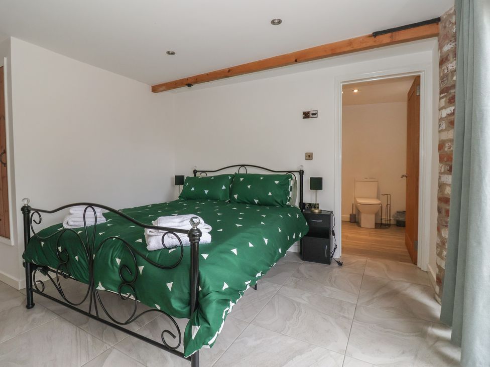 A bedroom with a bed and an adjoining bathroom at Pillar Barn Driffield
