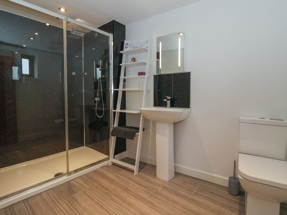 A bathroom with a shower, sink, and toilet at Pillar Barn in Driffield