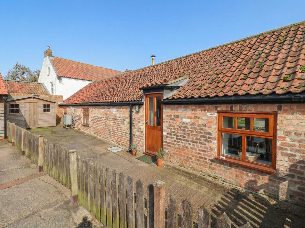 An outdoor area with a brick wall and garden shed at Pillar Barn in Driffield