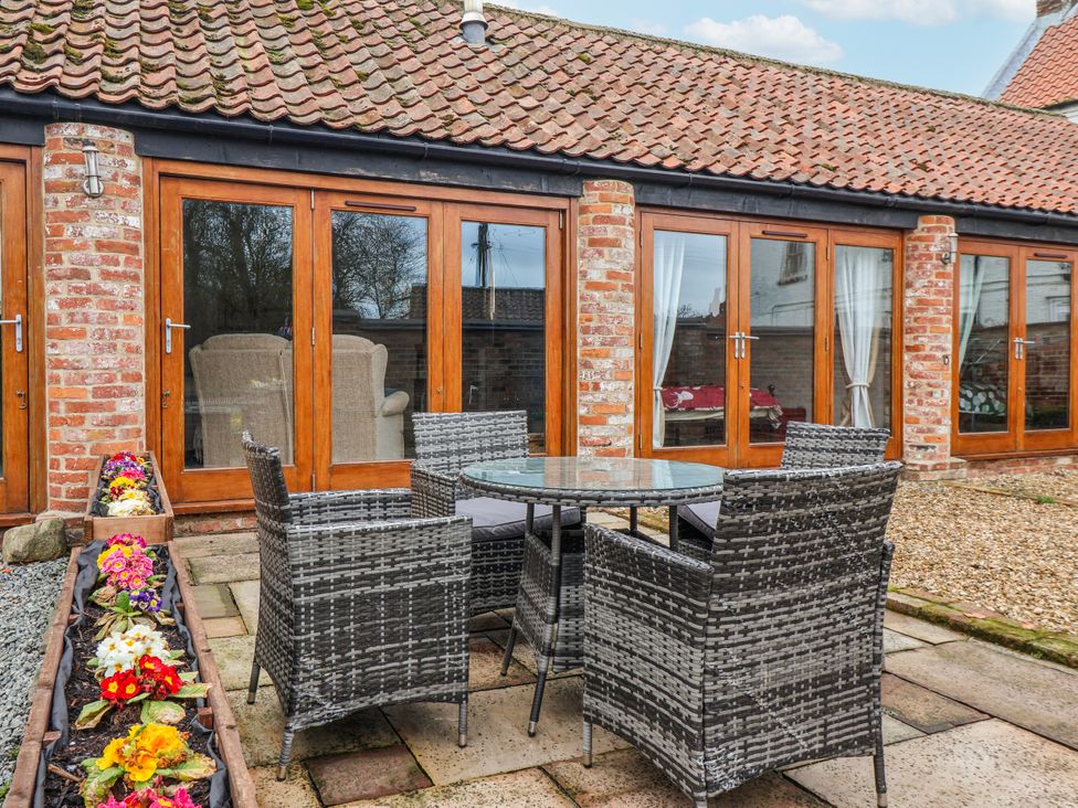 An outdoor seating area with a table and chairs at Pillar Barn Gransmoor near Bridlington