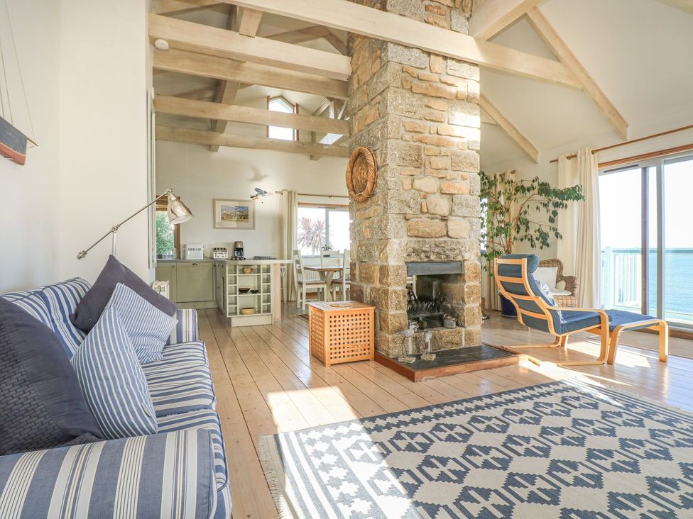 A living room with a fireplace and seating area at Harbour Lights in Penzance