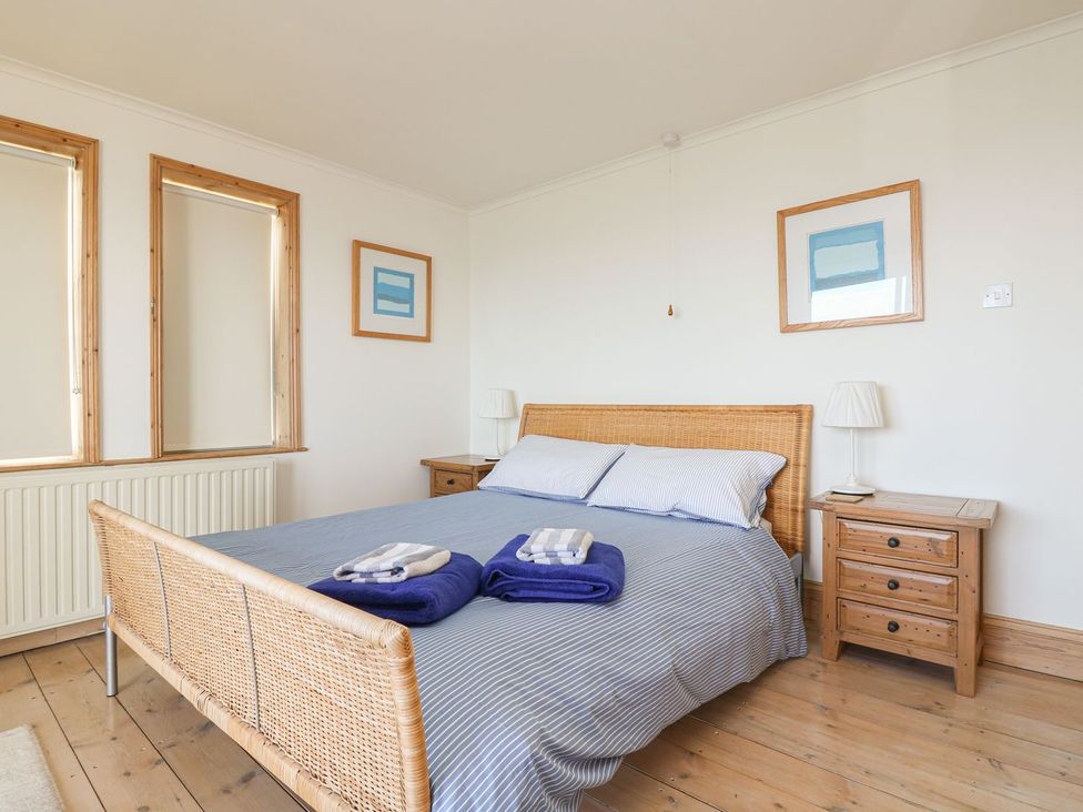 A bedroom with a bed and nightstand at Harbour Lights in Penzance