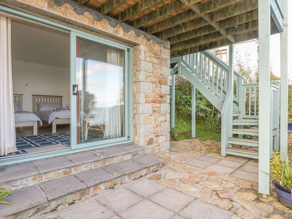 A bedroom with two beds and a sliding door at Harbour Lights Penzance