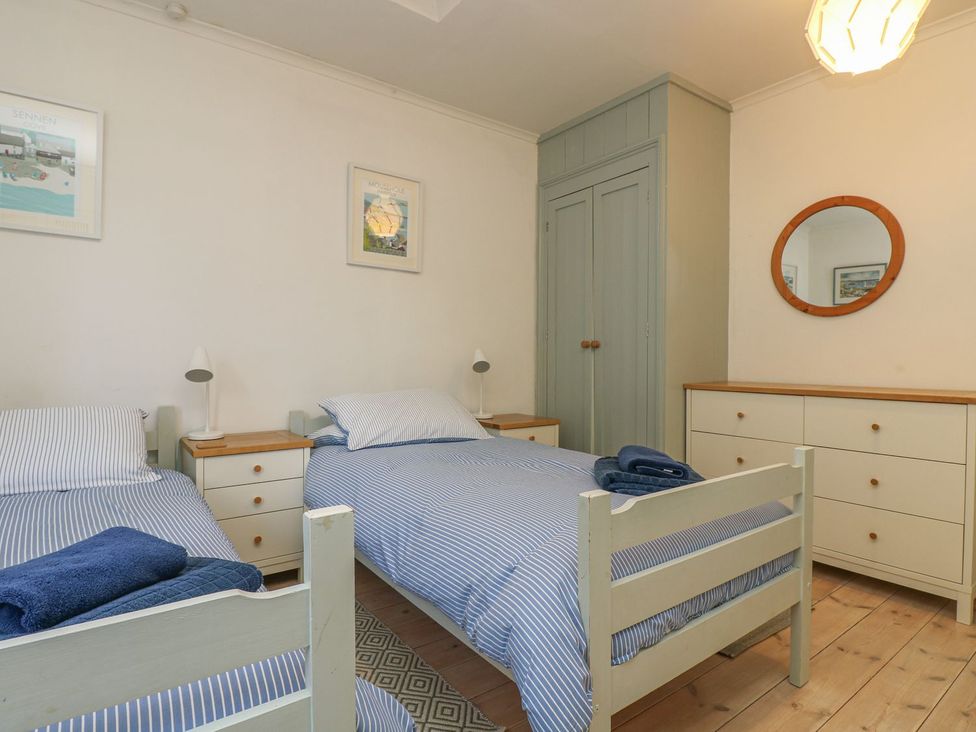 A bedroom with two single beds and a dresser at Harbour Lights in Penzance