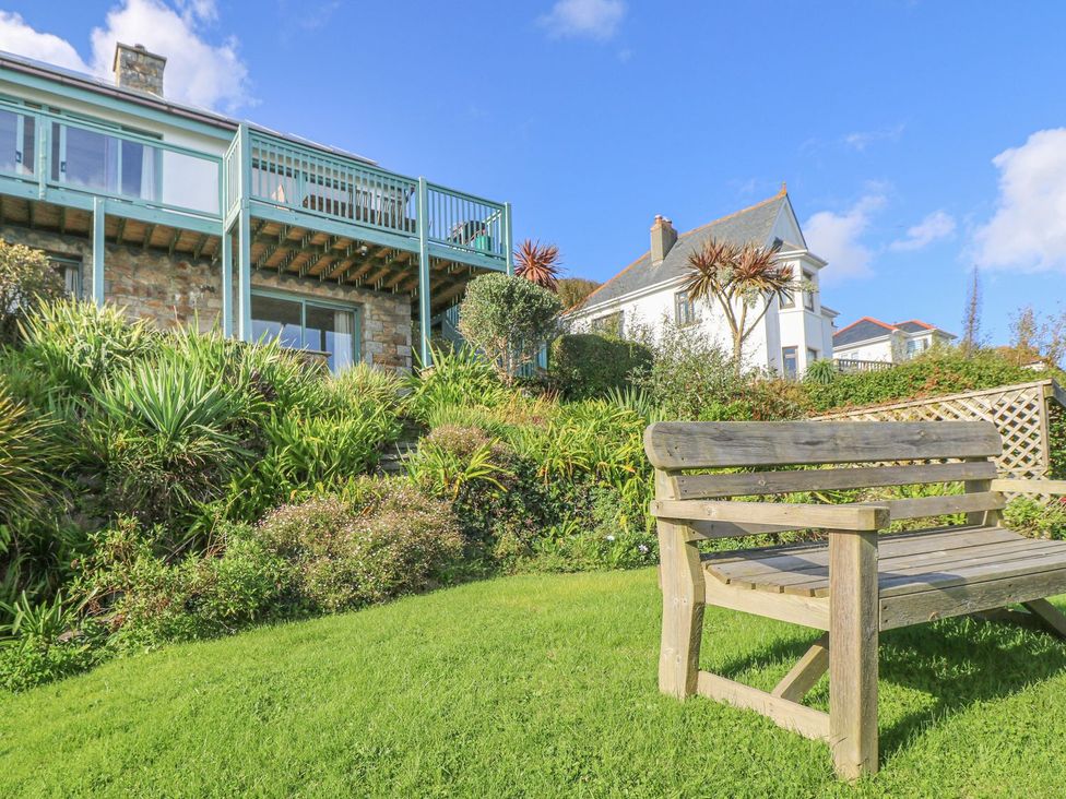 A garden with a bench and house in the background at Harbour Lights in Penzance