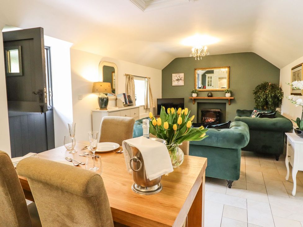 A dining area with a table and chairs at The Talkhouse Cottage in Caersws