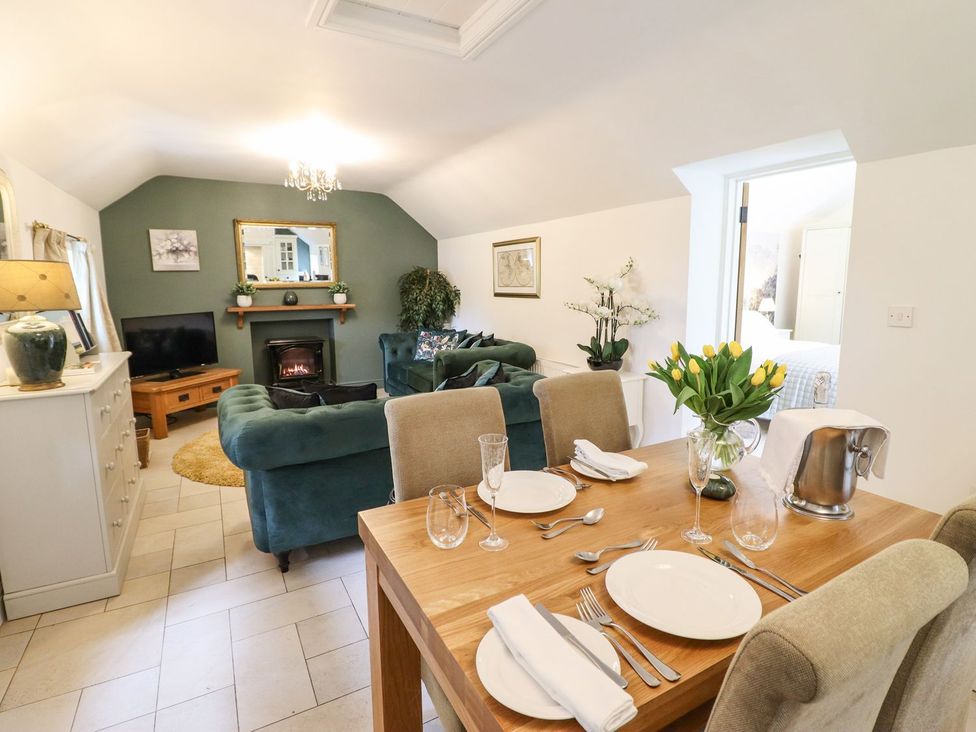A living room with a dining area and a sofa at The Talkhouse Cottage in Caersws